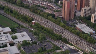 4.8K aerial stock footage of tracking a commuter train passing by Hyde Park, at twilight, Chicago, Illinois Aerial Stock Footage | AX0003_020