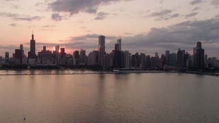 4.8K aerial stock footage of the Downtown Chicago skyline seen from Lake Michigan, on a cloudy day at sunset, Illinois Aerial Stock Footage | AX0003_032