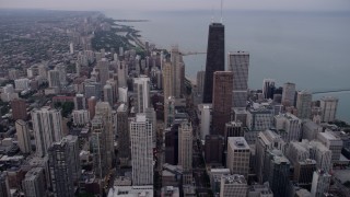 4.8K aerial stock footage of flying over Downtown Chicago, approach John Hancock Center on a cloudy day at sunset, Illinois Aerial Stock Footage | AX0003_050