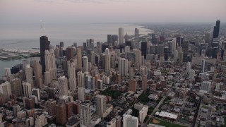 4.8K aerial stock footage of Downtown Chicago cityscape and John Hancock Center, on a cloudy day at sunset, Illinois Aerial Stock Footage | AX0003_055