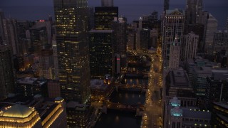 4.8K aerial stock footage of following the Chicago River through downtown at twilight, Downtown Chicago, Illinois Aerial Stock Footage | AX0003_117