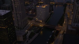 4.8K aerial stock footage of flying over a bridge spanning the Chicago River in downtown at twilight, Downtown Chicago, Illinois Aerial Stock Footage | AX0003_120