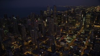 4.8K aerial stock footage tilt up and approach Downtown Chicago skyscrapers and high-rises at night, Illinois Aerial Stock Footage | AX0003_141