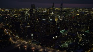 4.8K aerial stock footage of flying by Downtown Chicago cityscape, at night with clouds, Illinois Aerial Stock Footage | AX0003_161