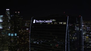 AX0004_043E - 5K aerial stock footage orbit Staples Center and The Ritz-Carlton at night in Downtown Los Angeles, California