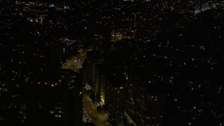 5K aerial stock footage of following Wilshire Boulevard through Westwood at night, California Aerial Stock Footage | AX0004_087E