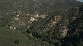 5K aerial stock footage of flying through canyon and reveal hilltop homes in the San Gabriel Mountains of California Aerial Stock Footage | AX0005_003E