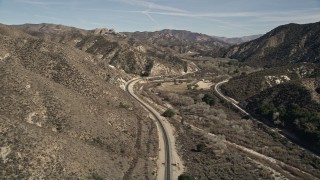 AX0005_020 - 5K aerial stock footage follow train tracks through mountainous countryside in Santa Clarita, California