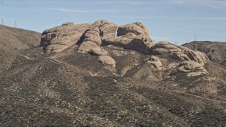 5K aerial stock footage reveal and approach Mojave Desert rock formations in California Aerial Stock Footage | AX0005_032