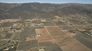 AX0005_049 - 5K aerial stock footage fly over arid rural homes and fields in Mojave Desert, California