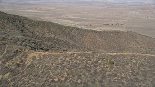 AX0005_057E - 5K aerial stock footage fly over mountain ridges to approach California Aqueduct in the Mojave Desert