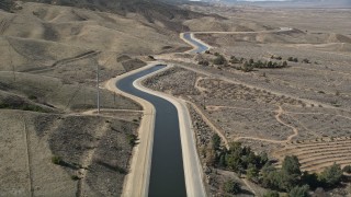 5K aerial stock footage of following the California Aqueduct by mountains in Mojave Desert, California Aerial Stock Footage | AX0005_061E