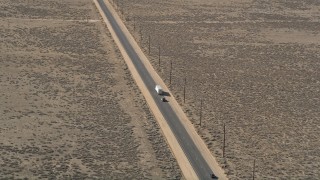 5K aerial stock footage orbit a big rig and SUV on a desert road in Antelope Valley Aerial Stock Footage | AX0005_075