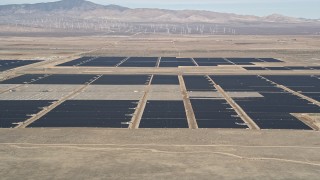 5K aerial stock footage fly low over desert hill and reveal solar array in Antelope Valley, California Aerial Stock Footage | AX0005_102