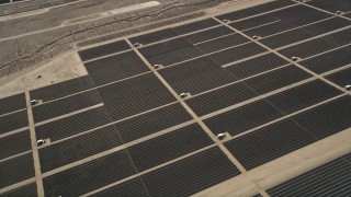 AX0005_110 - 5K aerial stock footage orbiting panels at a Mojave Desert solar array in California