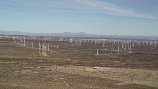 5K aerial stock footage pan across rows of windmills at desert wind farm in Antelope Valley, California Aerial Stock Footage | AX0006_006