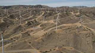 5K aerial stock footage of approaching a field full of windmills at a desert wind farm in Antelope Valley, California Aerial Stock Footage | AX0006_020E