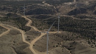 5K aerial stock footage orbit a single windmill at a desert wind farm in the Mojave Desert, California Aerial Stock Footage | AX0006_025