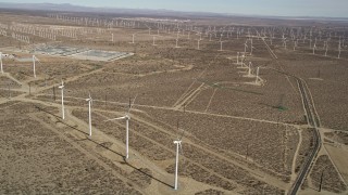 AX0006_041 - 5K aerial stock footage tilt to bird's eye of a windmill in a desert wind farm in California