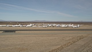 5K aerial stock footage of a low altitude orbit of planes at an aircraft boneyard in the desert, Mojave Air and Space Port, California Aerial Stock Footage | AX0006_057