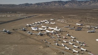 5K aerial stock footage orbit low around various jet airplanes at an aircraft boneyard in the desert, Mojave Air and Space Port, California Aerial Stock Footage | AX0006_058E