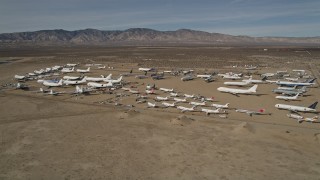 5K aerial stock footage orbit airplanes in a desert field at an aircraft boneyard, Mojave Air and Space Port, California Aerial Stock Footage | AX0006_069