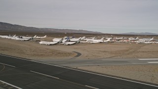 AX0006_071 - 5K aerial stock footage of flyby jet airplanes in a desert field at a California boneyard, Mojave Air and Space Port