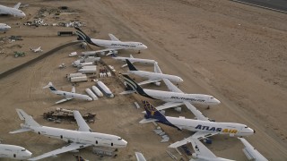 AX0006_087E - 5K aerial stock footage approach group of jet airplanes at a boneyard in the desert, Mojave Air and Space Port, California