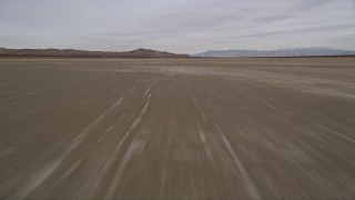 AX0006_136E - 5K aerial stock footage of flying low over dry El Mirage Lake in the Mojave Desert, California