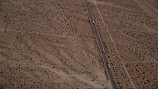 5K aerial stock footage tilt to bird's eye view of big rigs and cars on Highway 395 through Mojave Desert, California Aerial Stock Footage | AX0006_153