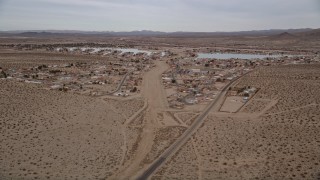 AX0006_162E - 5K aerial stock footage approach homes on the outskirts of the small desert town of Helendale, California