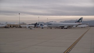 AX0007_001 - 5K aerial stock footage of low altitude orbit around cargo plane at Victorville Airport, California at Sunset