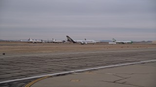 AX0007_002 - 5K aerial stock footage of a low altitude view of airliners at a boneyard at Victorville Airport, California at Sunset