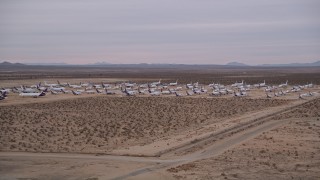 AX0007_005 - 5K aerial stock footage orbit several rows of cargo planes at an aircraft boneyard at Sunset, Victorville Airport, California