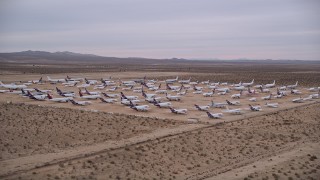 5K aerial stock footage orbit large group of cargo planes at an aircraft boneyard at Victorville Airport at Sunset, California Aerial Stock Footage | AX0007_006