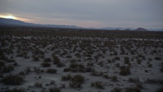 5K aerial stock footage ascend over desert to reveal homes in Mojave Desert, California, twilight Aerial Stock Footage | AX0007_029