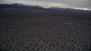 5K aerial stock footage tilt from desert to reveal mountains with light snow at twilight, Mojave Desert, California Aerial Stock Footage | AX0007_035