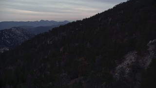 5K aerial stock footage of dense forest on snowy slopes in the San Gabriel Mountains at twilight, California Aerial Stock Footage | AX0008_033