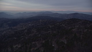 5K aerial stock footage fly over mountain with trees and snow patches, San Gabriel Mountains at twilight, California Aerial Stock Footage | AX0008_034