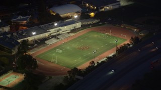 AX0008_069 - 5K aerial stock footage orbit a football field during nighttime practice at La Cañada Flintridge, California