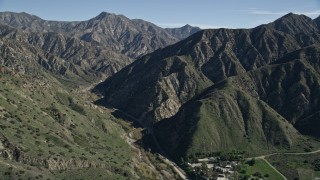 AX0009_008 - 5K aerial stock footage approach road at the base of green ridges in the San Gabriel Mountains, California