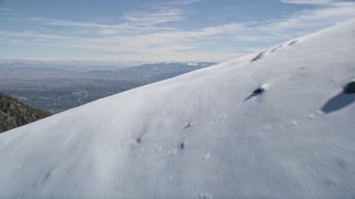 5K aerial stock footage fly over snowy slope to reveal smaller mountains in the San Gabriel Mountains, California Aerial Stock Footage | AX0009_061