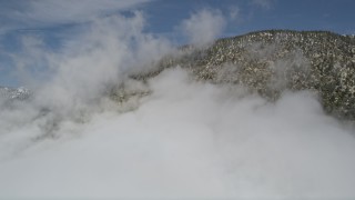 5K aerial stock footage of San Bernardino Mountains with light winter snow and clouds, California Aerial Stock Footage | AX0009_114