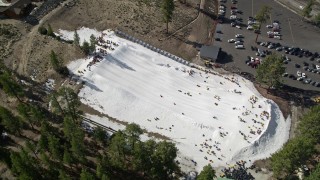 5K aerial stock footage approach people sliding down a frozen slope at Big Bear Lake in winter, California Aerial Stock Footage | AX0010_006