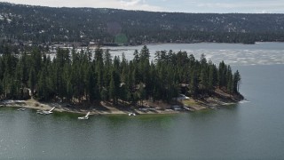 5K aerial stock footage of approaching lakeside homes at Big Bear Lake with patches of light winter snow, California Aerial Stock Footage | AX0010_014E