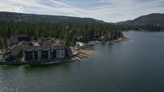 5K aerial stock footage orbit apartment building and homes on the shore of Big Bear Lake with winter snow, California Aerial Stock Footage | AX0010_019