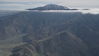 5K aerial stock footage tilt from windmills to reveal a peak in the San Jacinto Mountains, California Aerial Stock Footage | AX0010_084