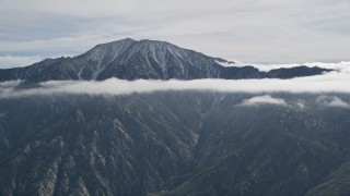 5K aerial stock footage of tall mountain peak ringed by clouds in the San Jacinto Mountains, California Aerial Stock Footage | AX0010_086