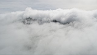 5K aerial stock footage approach peak with light snow covered by clouds in the San Jacinto Mountains, California Aerial Stock Footage | AX0010_091E