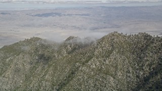 5K aerial stock footage of rugged mountain ridge in the San Jacinto Mountains with Coachella Valley in the distance, California Aerial Stock Footage | AX0010_103